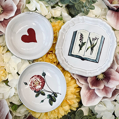 Decorative Astier de Villatte Plates atop floral background.