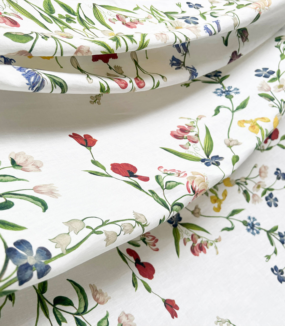 Floral tablecloth close-up with colourful flowers on a white french linen background