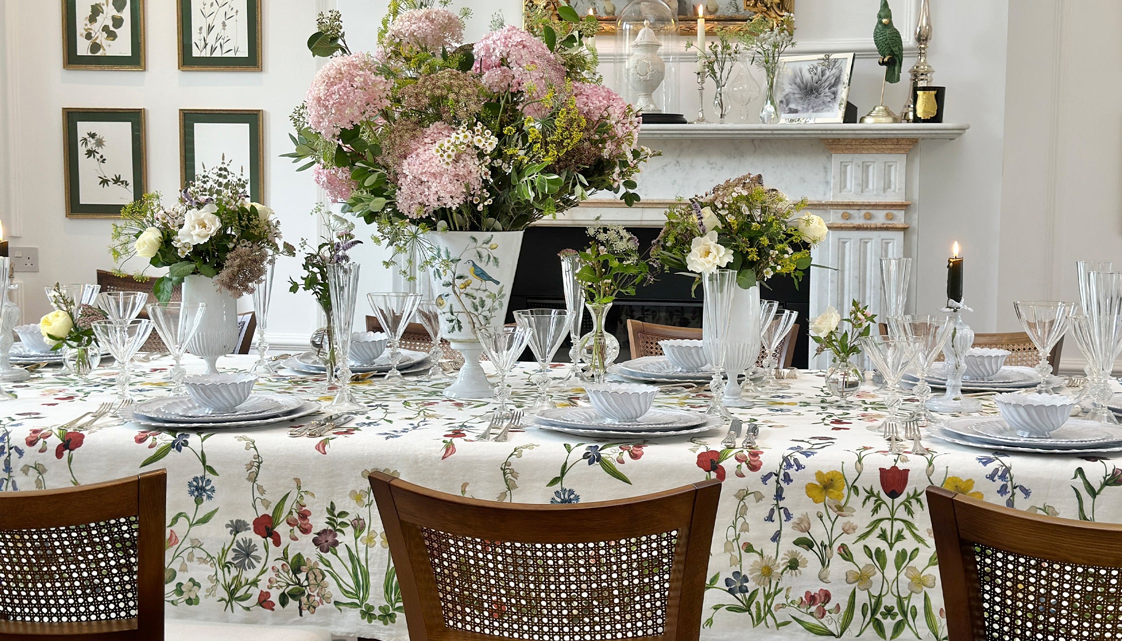 Elegant dining room with a table set for a meal, featuring floral centerpieces and tablecloth.