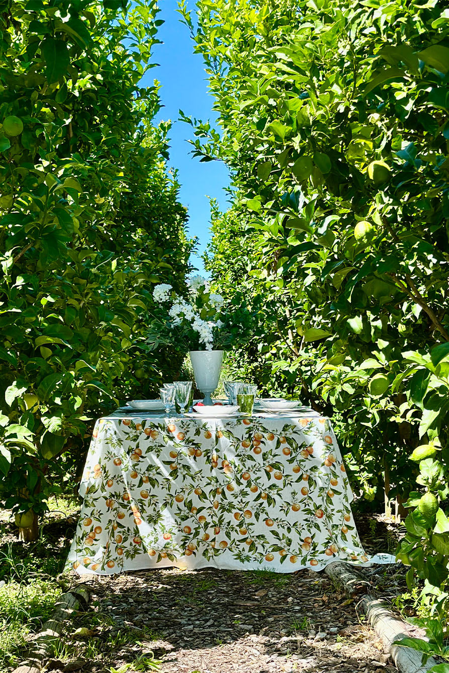 Table set with a orange branch linen tablecloth amongst orange trees
