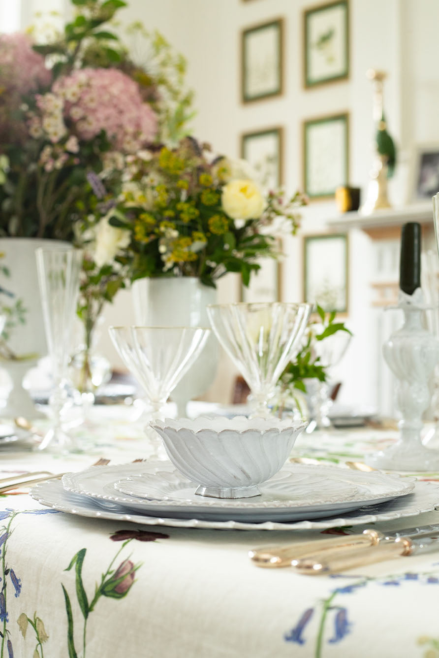 Elegant table setting with Botanical Wildflower tablecloth, floral centerpieces and Astier de Villatte Peggy plates.